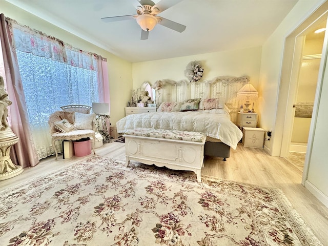 bedroom with light wood-style floors, baseboards, and ceiling fan