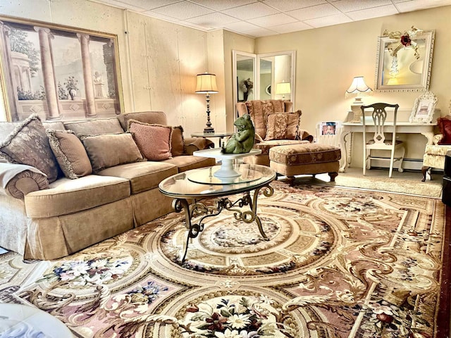 living area featuring baseboard heating and a drop ceiling