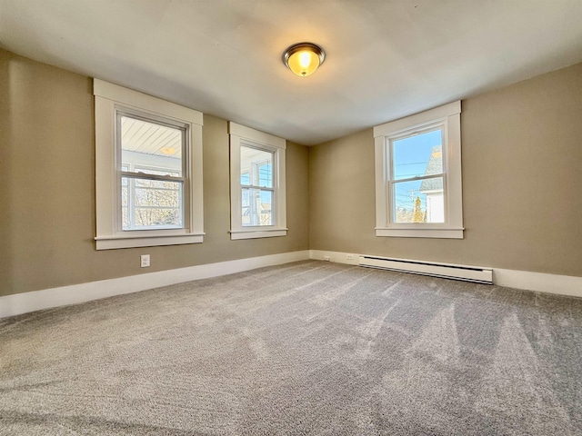 carpeted spare room with a baseboard heating unit and baseboards