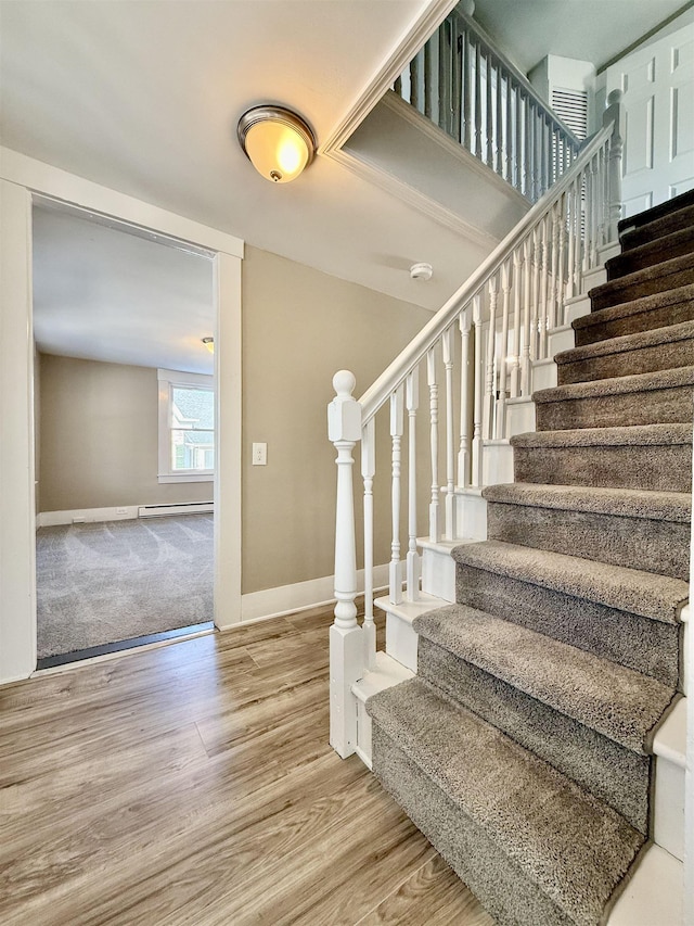 stairway with wood finished floors and baseboards