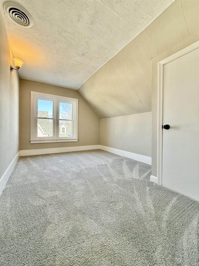 bonus room featuring visible vents, carpet flooring, a textured ceiling, and vaulted ceiling