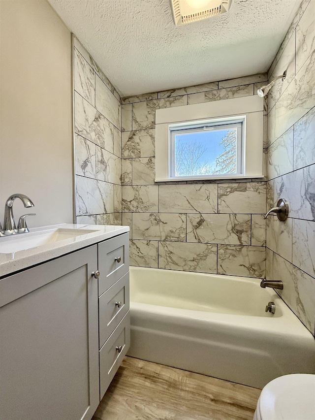 full bathroom with visible vents, toilet, shower / tub combination, wood finished floors, and vanity