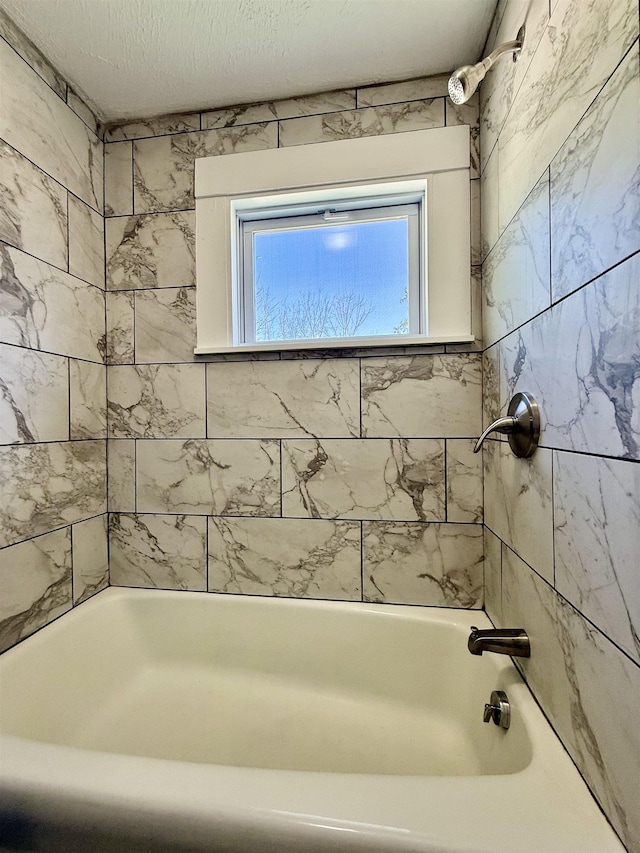 full bathroom featuring a textured ceiling and shower / bath combination