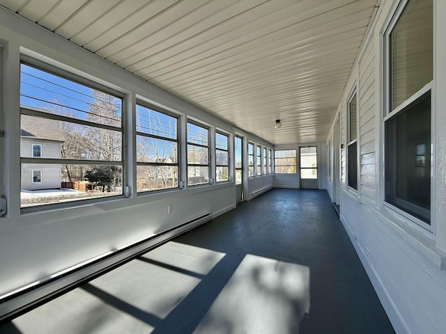 unfurnished sunroom with a baseboard heating unit