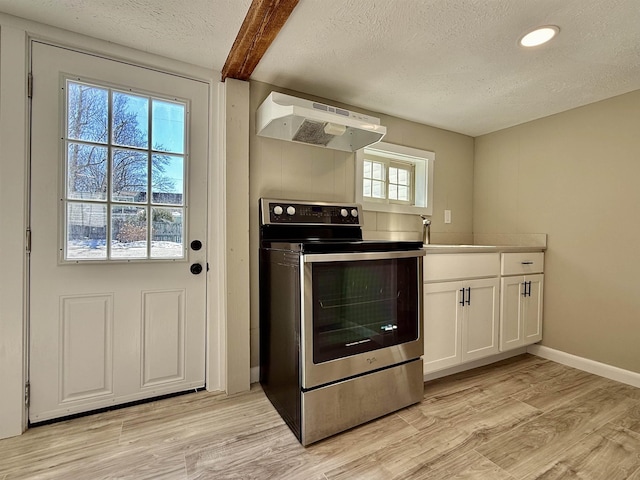 kitchen with light wood-style flooring, a sink, stainless steel range with electric cooktop, under cabinet range hood, and a textured ceiling