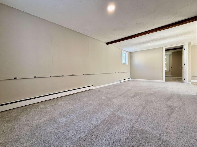 empty room with beam ceiling, carpet, baseboard heating, and a textured ceiling