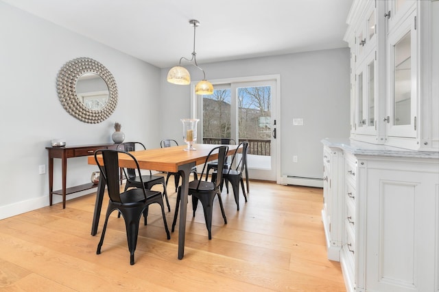 dining room featuring baseboards, light wood-type flooring, and baseboard heating