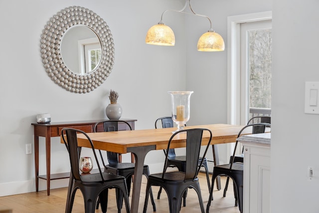 dining area with baseboards and light wood-style floors