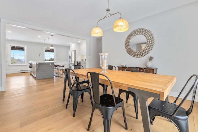 dining room featuring recessed lighting, a baseboard heating unit, and light wood-style floors