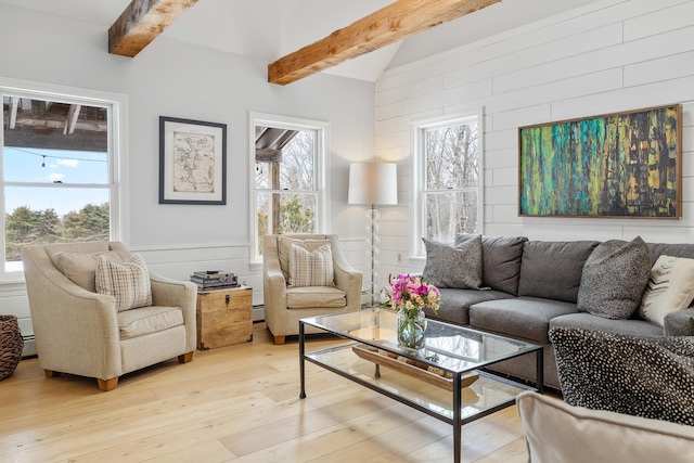 living area featuring vaulted ceiling with beams, light wood-type flooring, and a baseboard radiator