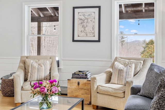 sitting room featuring a baseboard heating unit and wood finished floors