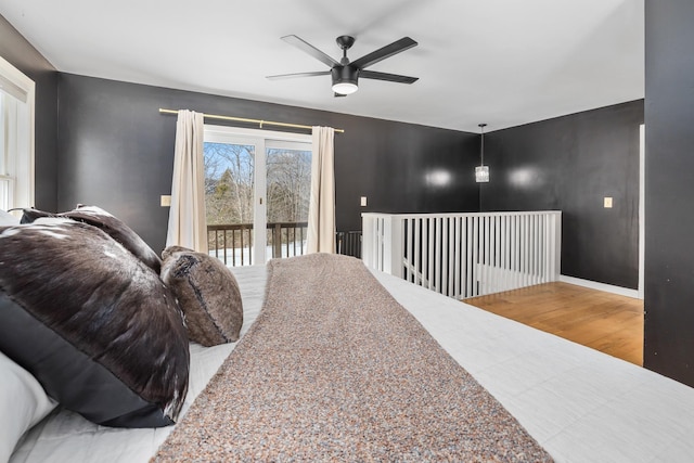 bedroom with ceiling fan, baseboards, wood finished floors, and access to exterior