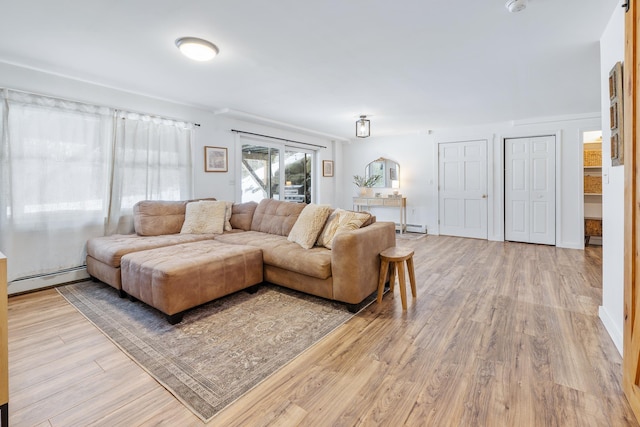 living room featuring a baseboard radiator, baseboards, light wood-style flooring, and a baseboard heating unit