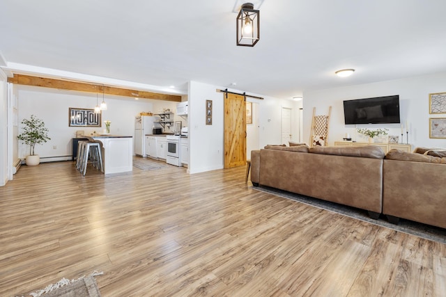 living room with a barn door, baseboards, light wood-style flooring, and a baseboard heating unit