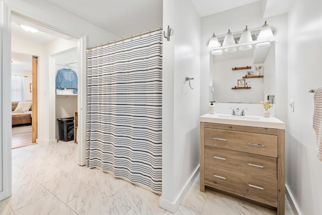 full bathroom featuring curtained shower, baseboards, marble finish floor, and vanity