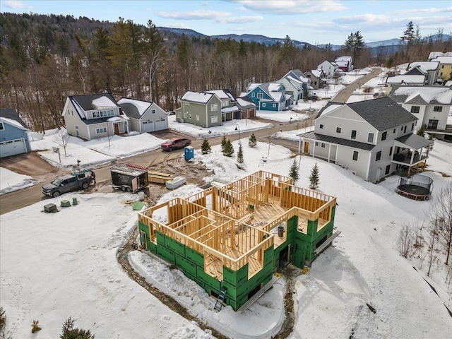 snowy aerial view featuring a forest view and a residential view