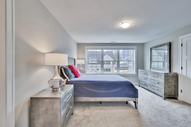 bedroom featuring multiple windows and light carpet