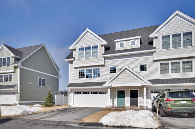 view of front of house with a garage, fence, aphalt driveway, and a shingled roof