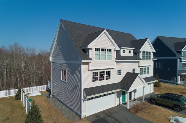 view of front of property with a garage, fence, driveway, and a shingled roof