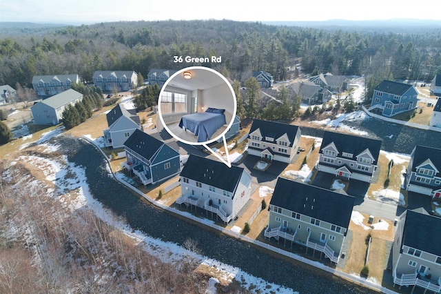 drone / aerial view featuring a wooded view and a residential view