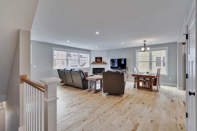 living room with a wealth of natural light, recessed lighting, light wood-style flooring, and a large fireplace