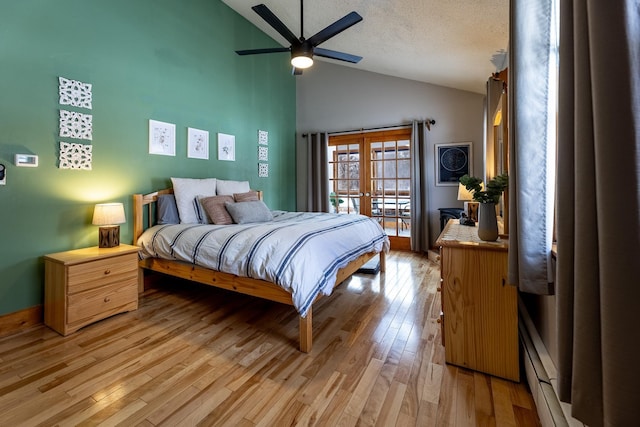 bedroom with light wood-type flooring, a textured ceiling, french doors, a baseboard radiator, and ceiling fan