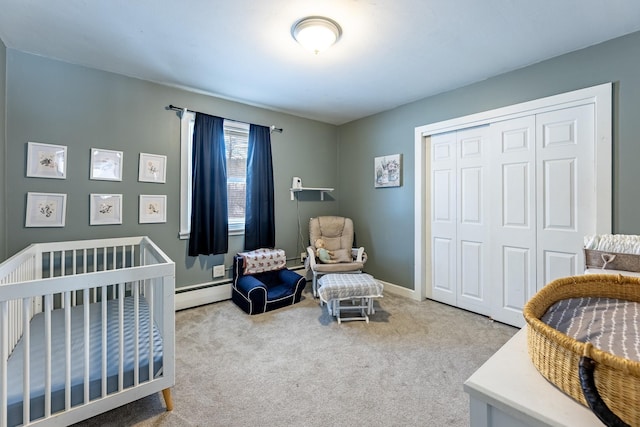 carpeted bedroom with a closet, a crib, baseboards, and a baseboard radiator