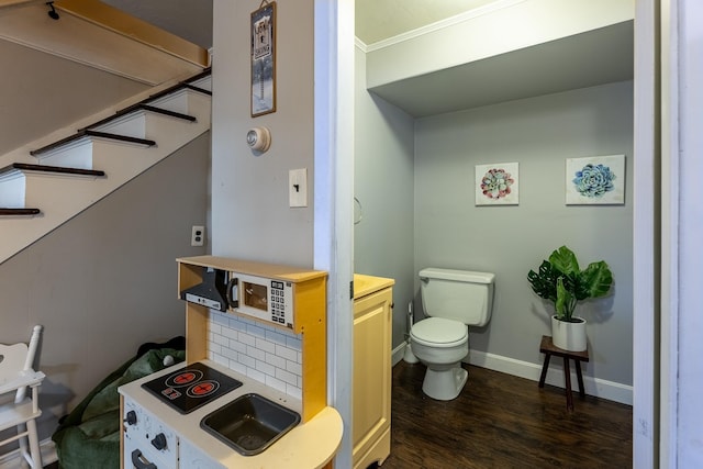 bathroom featuring backsplash, baseboards, toilet, and wood finished floors