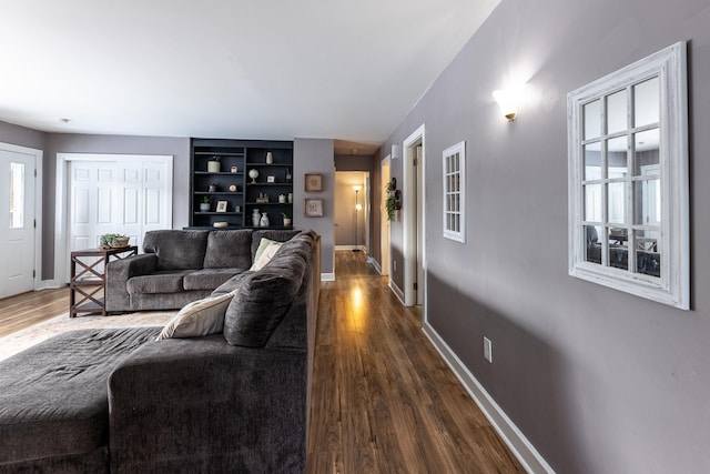 living area featuring baseboards and dark wood-style flooring