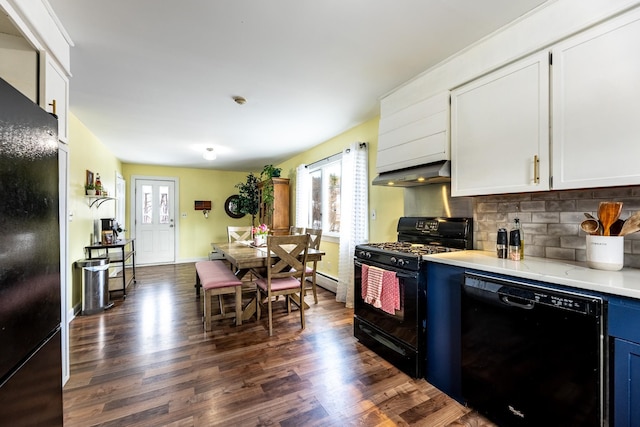 kitchen with dark wood-style flooring, black appliances, light countertops, and exhaust hood