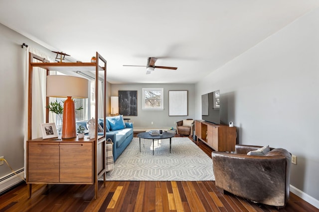 living area featuring a ceiling fan, wood finished floors, baseboards, and baseboard heating