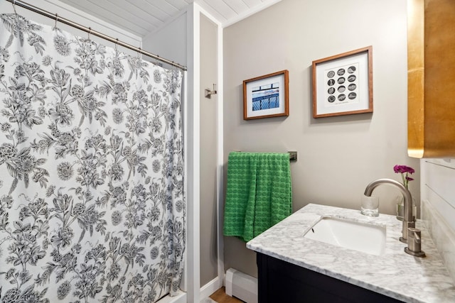 full bath with a shower with shower curtain, a baseboard heating unit, and vanity