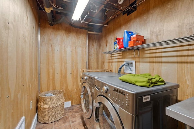 washroom featuring visible vents, separate washer and dryer, wooden walls, and laundry area