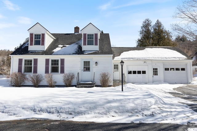 cape cod house with a chimney and a garage