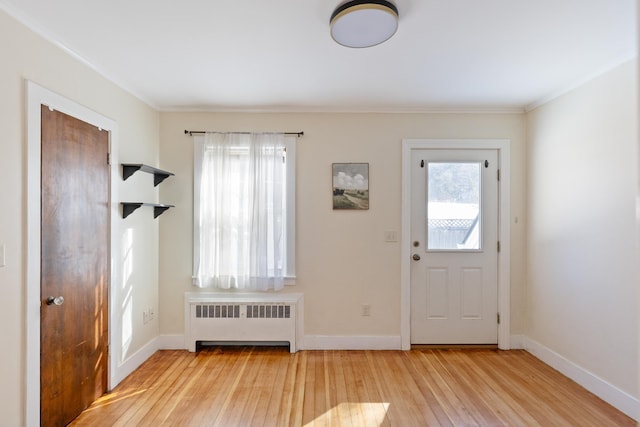 foyer featuring baseboards, wood-type flooring, and radiator heating unit