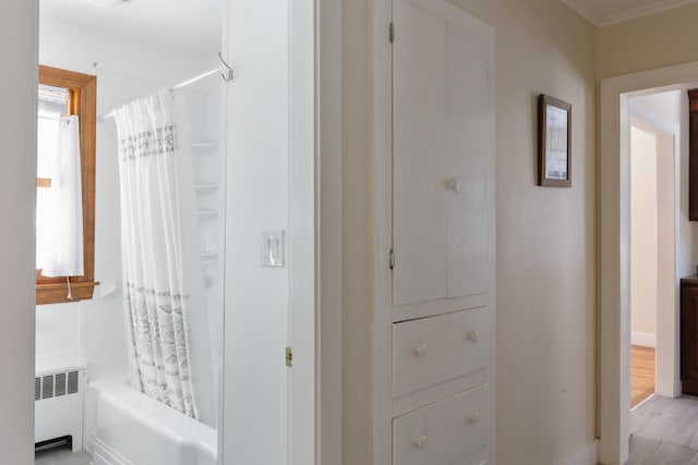 bathroom with shower / bath combo with shower curtain and radiator heating unit