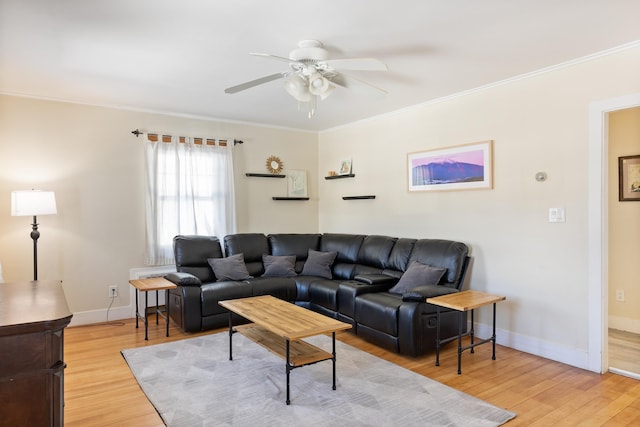 living room featuring baseboards, ornamental molding, a ceiling fan, and light wood finished floors