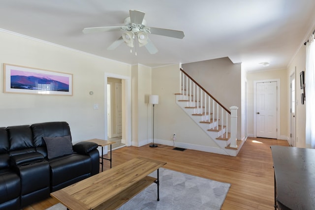 living area with light wood finished floors, visible vents, crown molding, baseboards, and stairway