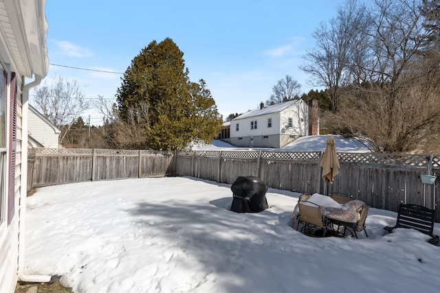 yard covered in snow with a fenced backyard