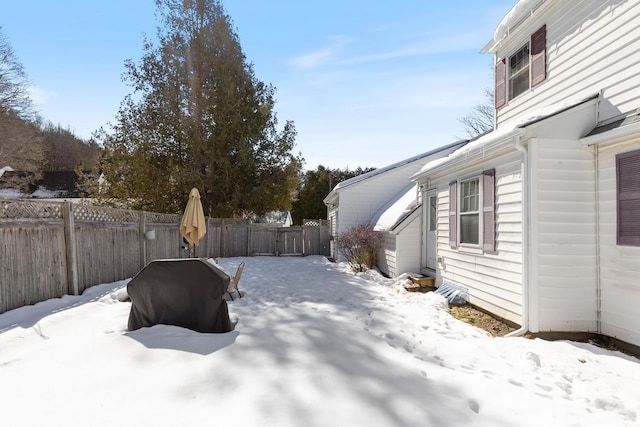 snowy yard featuring a fenced backyard