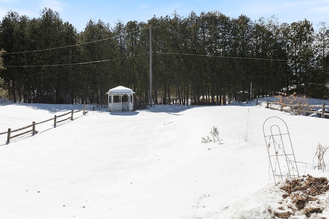 yard layered in snow with a view of trees