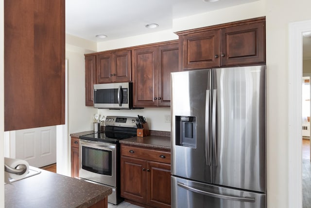 kitchen with dark countertops and appliances with stainless steel finishes