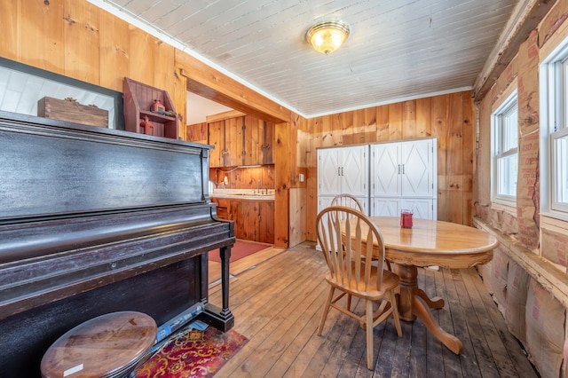 dining space with wood walls and wood-type flooring