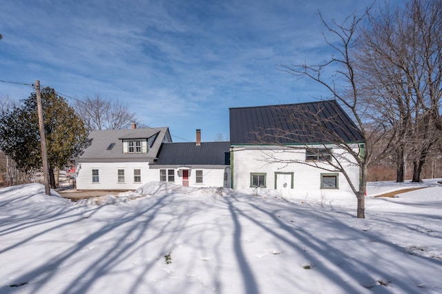 snow covered back of property with metal roof