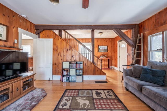 living area with hardwood / wood-style floors, stairway, and wood walls