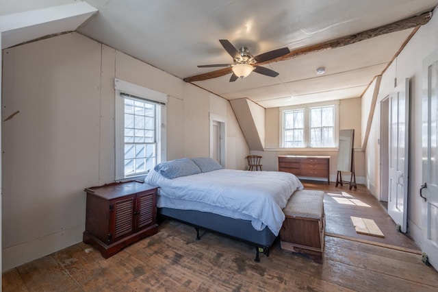 bedroom featuring lofted ceiling, hardwood / wood-style flooring, multiple windows, and ceiling fan