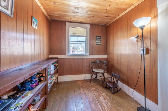 living area featuring wooden ceiling, wood walls, and hardwood / wood-style flooring