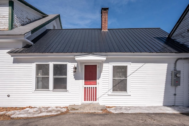 exterior space featuring metal roof and a chimney