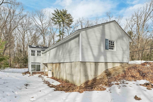 view of snowy exterior with a sunroom