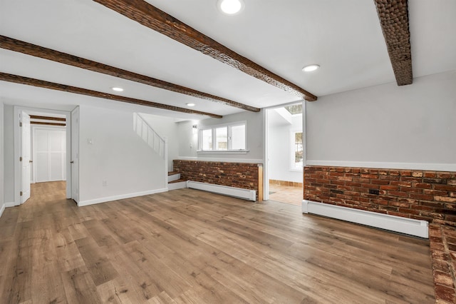 unfurnished living room featuring stairs, beamed ceiling, wood finished floors, and a baseboard radiator